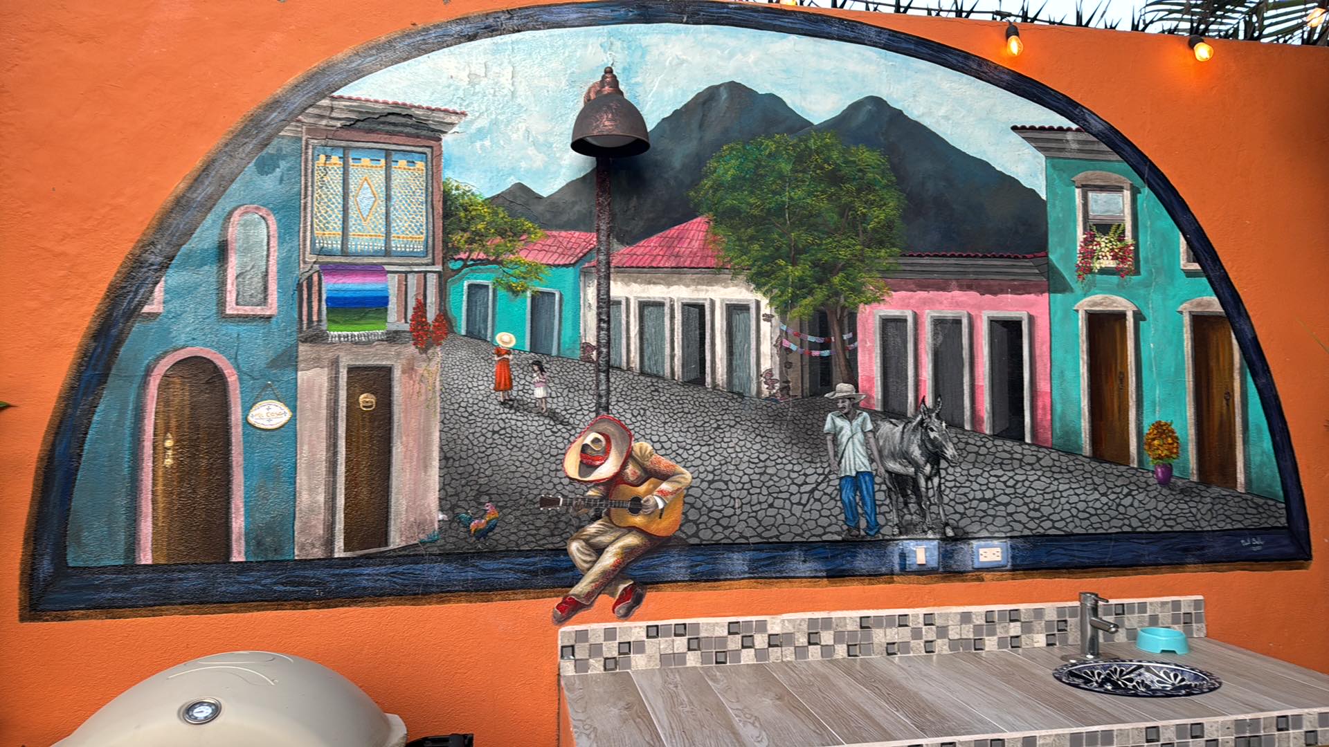 Hand-painted mural of a Mexican village scene with mariachi player